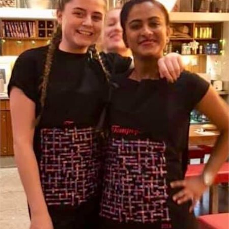 photo of girls wearing tampopo name-chains aprons